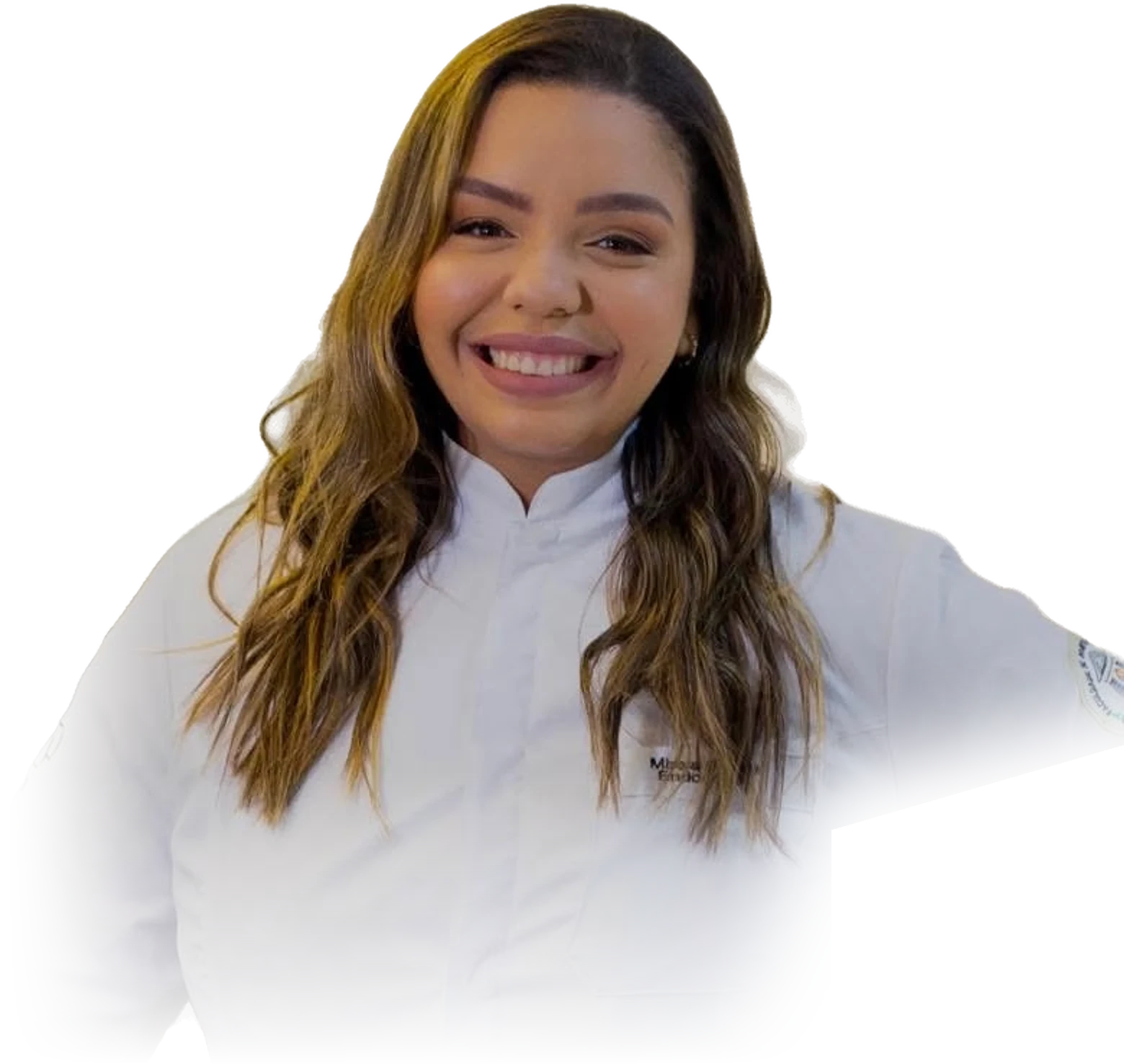 A Dra. Mirela Barros sorrindo, de jaleco branco, com o cabelo ondulado solto sobre os ombros.
