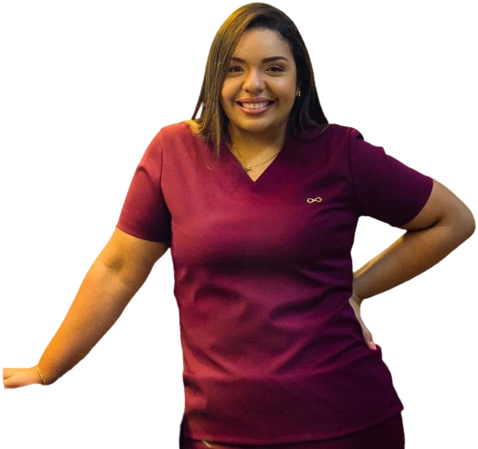 A Dra. Mirela Barros de scrub bordô, sorrindo, com a mão na cintura.