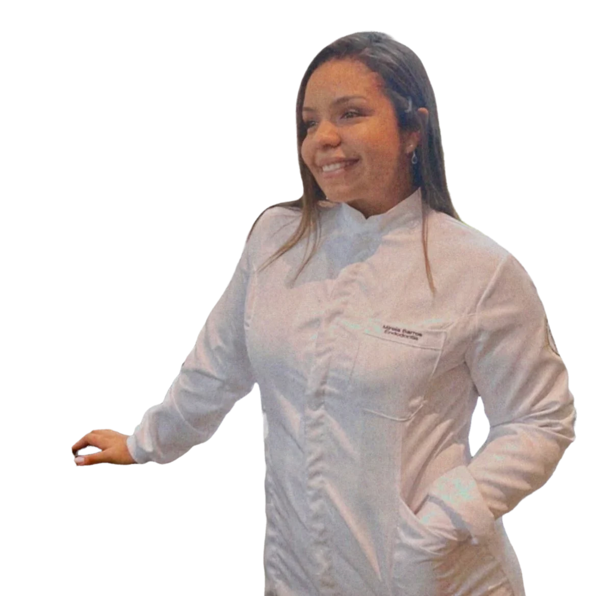 A Dra. Mirela Barros de jaleco branco, sorrindo, com a mão apoiada.